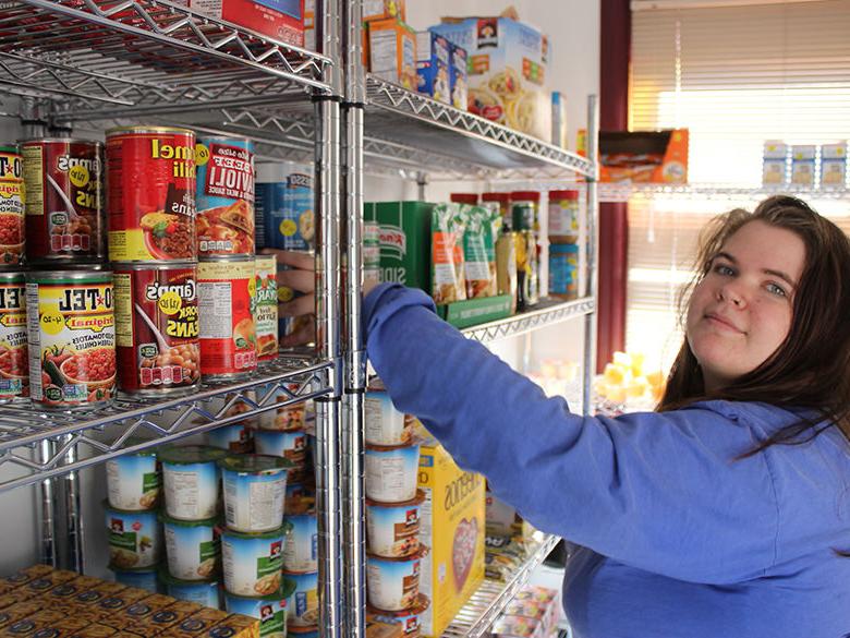 A female student helps stock the Lion's Pantry